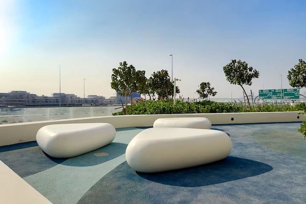 Una terraza en la azotea con mobiliario blanco moderno y vistas a la ciudad.