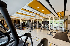 A gym with exercise equipment, mirrors, and a large window. - Vogue, Damac Hills Golf Gate near First Avenue Mall (Dubai)
