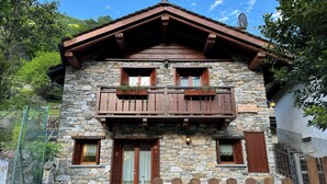 A stone building with a wooden balcony, a wooden fence, and a stone wall.