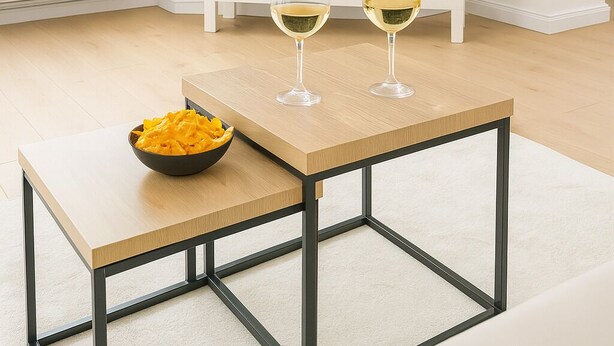 Ein modernes Wohnzimmer mit einem Fernseher, der das Netflix-Logo zeigt, einem Couchtisch mit einer Schüssel Snacks und zwei Weingläsern.