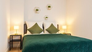 Ein Schlafzimmer mit einem großen Bett, zwei Nachttischen und drei Wandlampen.
