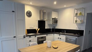Una cucina moderna con mobili bianchi, un tavolo da pranzo in legno e un pannello di rivestimento bianco e nero.