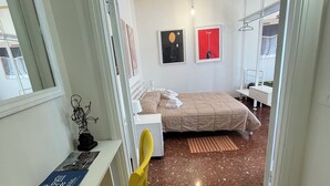 Una camera da letto con un letto, una scrivania, una sedia e un armadio.