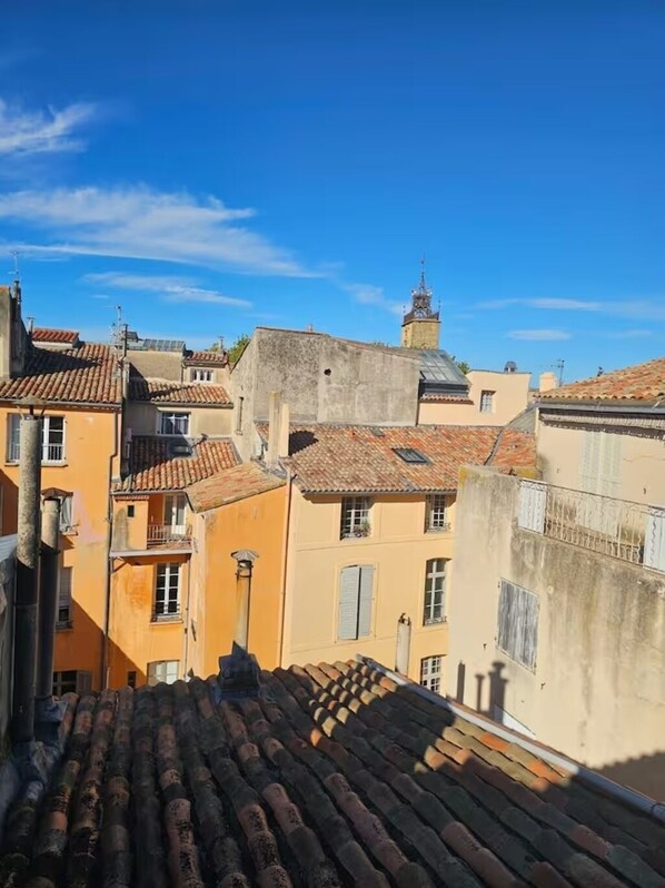 A view of a residential area with terracotta-tiled roofs and buildings with balconies.
