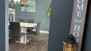 A modern dining area with a gray wall, a wooden floor, and a chandelier. - Charming 4-bedroom house with WiFi, AC in wonderful Scotrun (Scotrun)