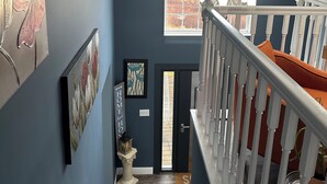 A staircase with white railings and orange cushions, leading to a landing with a view of a brick wall and a window. - Charming 4-bedroom house with WiFi, AC in wonderful Scotrun (Scotrun)