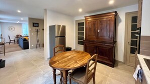 Una cucina moderna con un tavolo da pranzo in legno, forno integrato e un ampio armadio.
