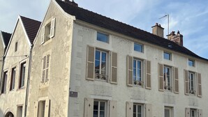 Un edificio di due piani con diverse finestre, una porta e un piccolo balcone.
