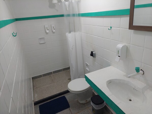 Un bagno piccolo con il water, un lavandino e una doccia.