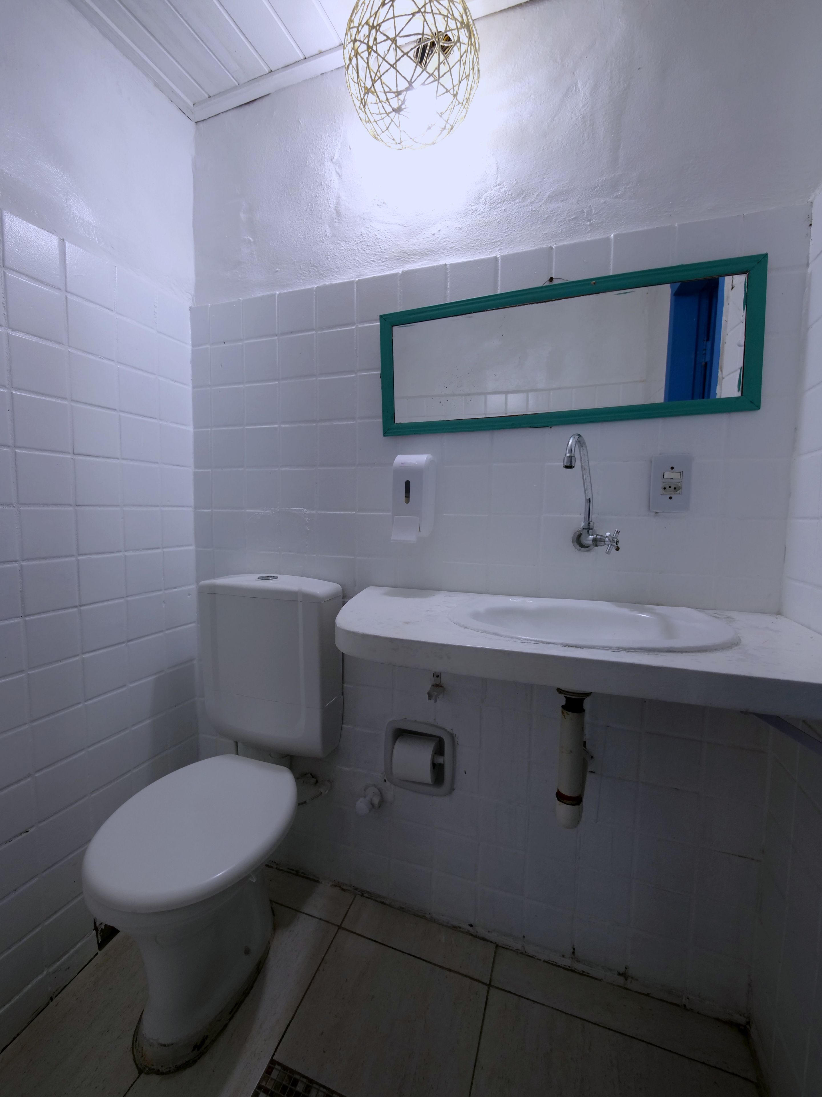 A small bathroom with a toilet, sink, and mirror.