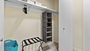 A walk-in closet with a metal rack, shelves, and a hanging rack. - Comfortable 2BR ! Free parking ! 30 min to NYC ! (Newark)