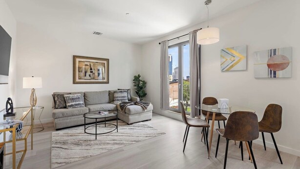 A modern living room with a sofa, coffee table, and dining area.