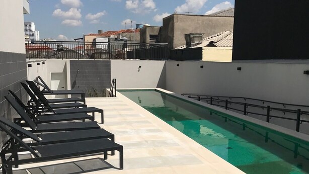 A rooftop pool area with lounge chairs and a clear view of the cityscape. - Vita 1409 Centro SP Bom Retiro - Digital Check-in with Wi-Fi (Bom Retiro São Paulo)