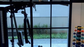 A gym with exercise equipment, large windows, and a view of greenery outside. - Vita 1409 Centro SP Bom Retiro - Digital Check-in with Wi-Fi (Bom Retiro São Paulo)