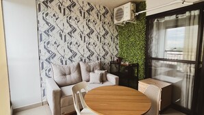 A modern living room with a sofa, a round wooden table, and a small coffee table. - Vita 1409 Centro SP Bom Retiro - Digital Check-in with Wi-Fi (Bom Retiro São Paulo)