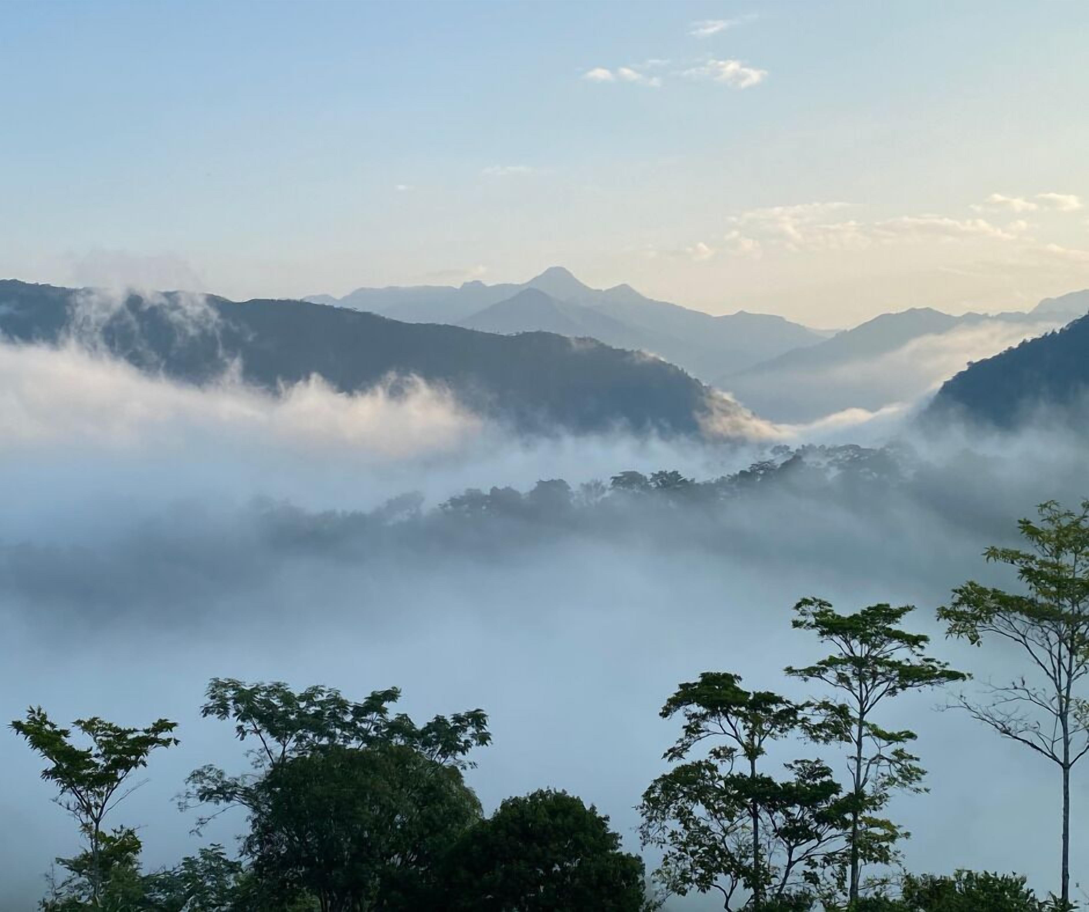 A mountainous landscape with dense fog covering the valleys and peaks.