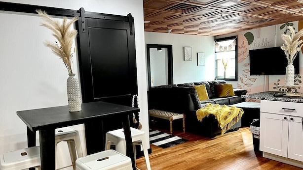 Un espacio habitable moderno con comedor, sofá y cocina.