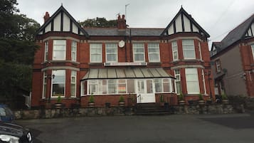 A two-story building with a bay window and a sign reading "Bay Tree Lodge".