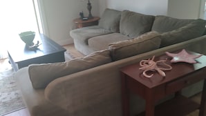 Un salon avec un canapé, une petite table et une lampe.
