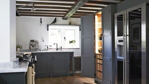 A kitchen with a built-in oven, a coffee machine, and a window with a view.