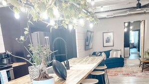 Una cucina moderna con un'isola in legno, sgabelli da bar e una pianta pensile.