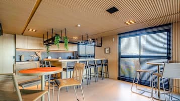 A modern interior with a kitchen, dining area, and large windows.