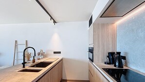 A modern kitchen with a central island, built-in appliances, and a minimalist design.