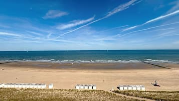 Une plage avec des tentes blanches et une zone sablonneuse.