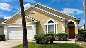 A residential house with a garage, a front door, and a well-maintained lawn.