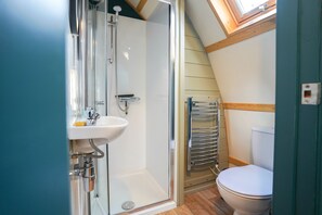 A compact bathroom with a shower, sink, and toilet. - Deluxe Cosy Cabin With Wood Fired Hot Tub (Spalding)