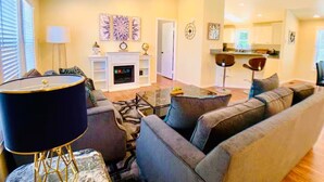 A living room with a fireplace, a sofa, a coffee table, and a lamp. - Sunmist Farm House in a 35 acres grove (Temecula)