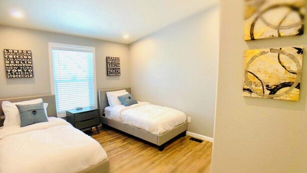 A bedroom with two beds, a window with blinds, and wall art. - Sunmist Farm House in a 35 acres grove (Temecula)