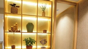Ein modernes Interieur mit einer Holzeinrichtung, die verschiedene Dekorationsgegenstände und Pflanzen zeigt.