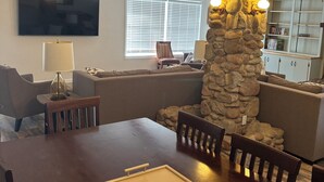 A dining area with a wooden table, chairs, and a stone pillar with lights. - Country Home, 4 Bed, 3.5 Bath, Pet Friendly (Warren)