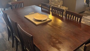A dining area with a wooden table, chairs, and a stone pillar. - Country Home, 4 Bed, 3.5 Bath, Pet Friendly (Warren)