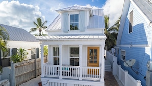 A two-story house with a porch, a wooden door, and a satellite dish. - SOUTHERN CROSS: 3 BR, 3.5 BA home in Old Town Key West with Private Pool & AC! (Key West)
