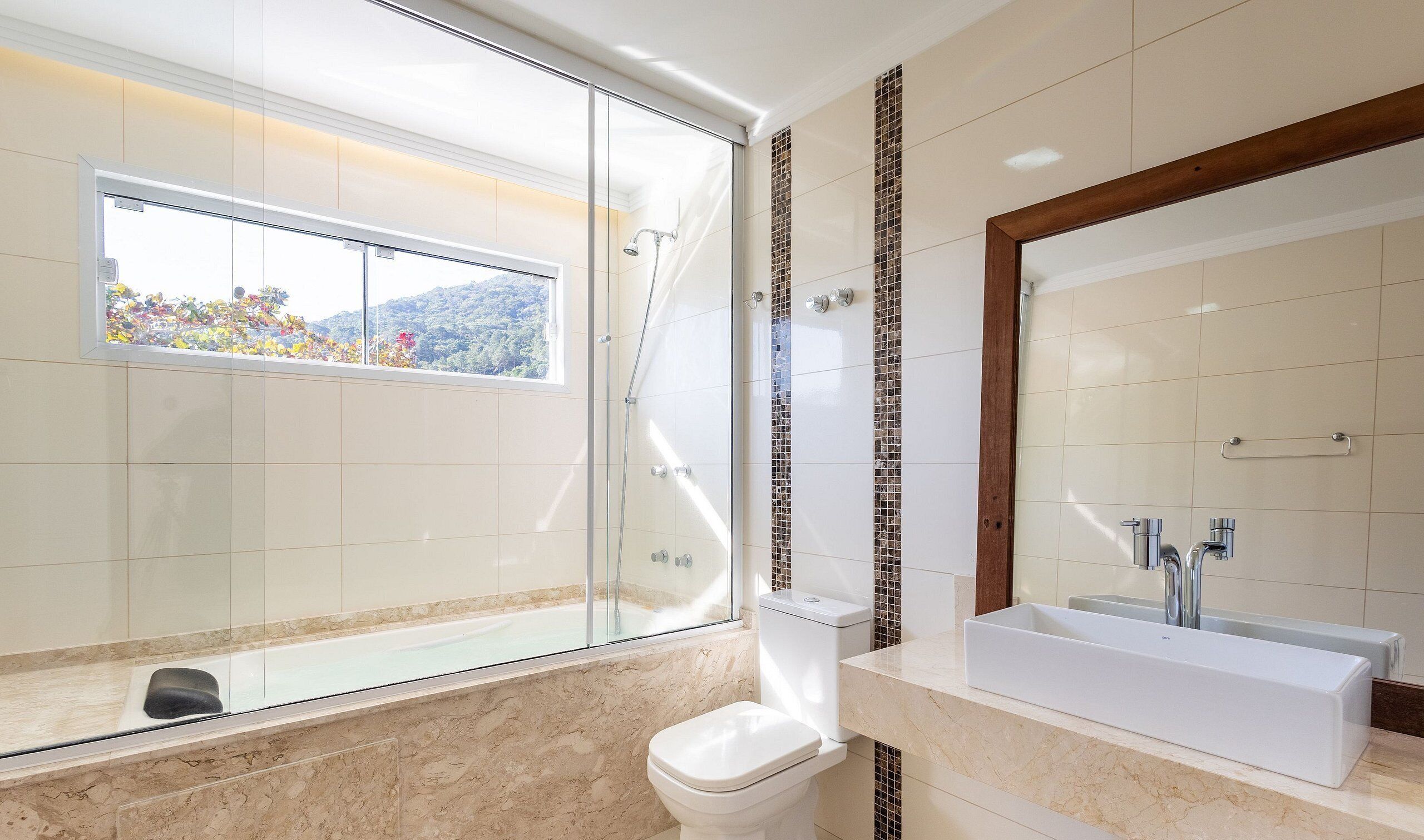 A modern bathroom with a glass-enclosed shower, a large mirror, and a bathtub.