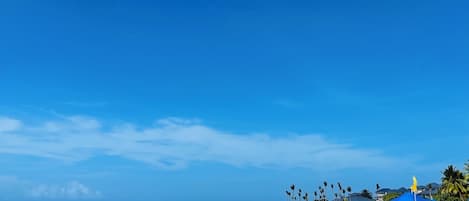 Praia particular, areia branca, espreguiçadeiras, guarda-sóis