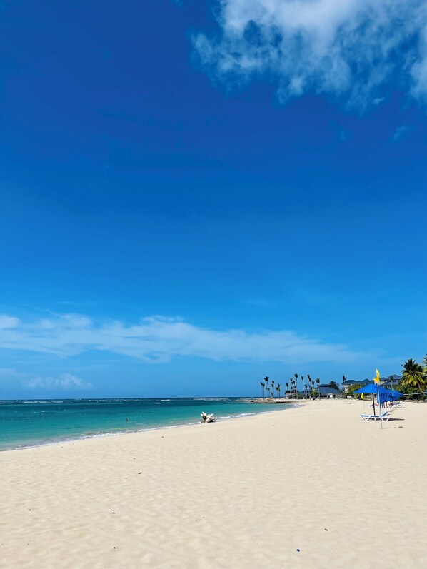 Privat strand, vit sandstrand, solstolar och parasoller