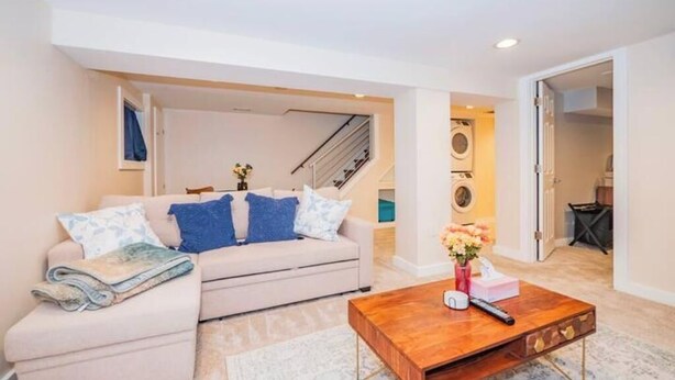 Un salon avec un canapé, une table basse et un escalier en arrière-plan.