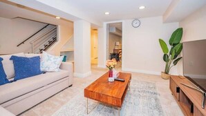 Un salon moderne avec un canapé, une table basse et un meuble pour la télévision.
