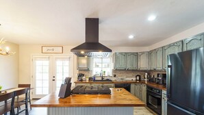 Una cocina moderna con una isla central, electrodomésticos de acero inoxidable y muebles de madera.