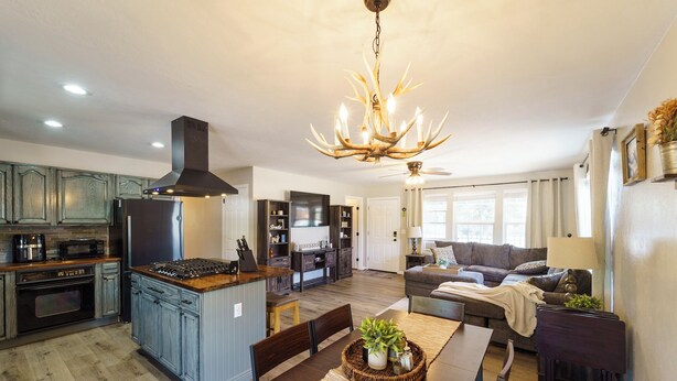 Amplia sala de estar con una isla central, una mesa de comedor y una cocina equipada con electrodomésticos modernos.