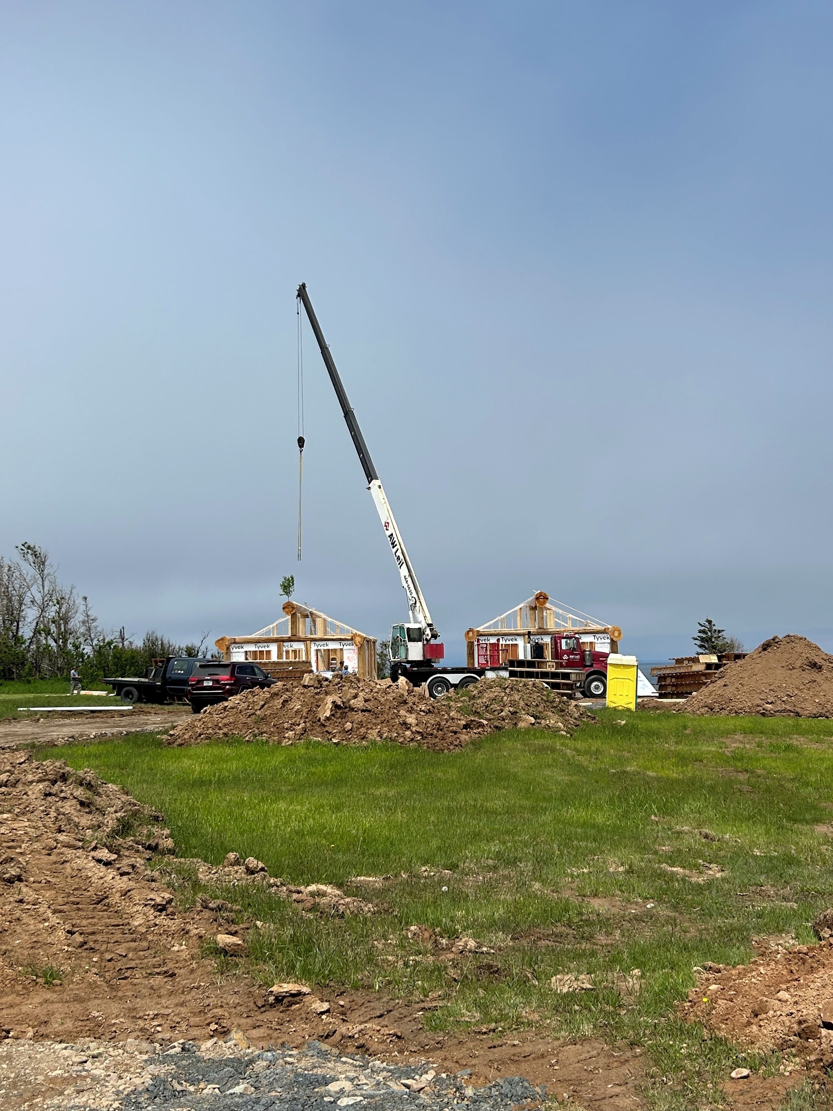 Un sitio de construcción con una grúa, un camión y un edificio en construcción.