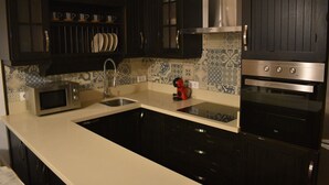 A kitchen with dark cabinets, a microwave, a sink, and an oven. - Bodeguetas 1 bedroom with patio pets welcome (Constantina)