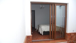 A bedroom with a bed, a sliding glass door, and a tiled floor. - Bodeguetas 1 bedroom with patio pets welcome (Constantina)