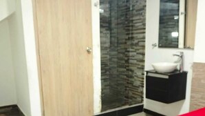 A bedroom with a bed, a wardrobe, a bathroom with a sink, and a mirror. - Hotel Casa Girardot (Medellin)