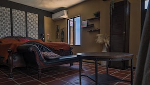 Une pièce comprenant un lit, un canapé, une table et une fenêtre.