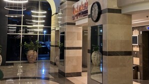 A modern lobby with a large clock, a digital display, and a parking sign. - MARINA LUXURY APARTMENT WITH TERRACE EXCEPTIONAL SEA VIEW BEACH 3 MN (Ashdod)