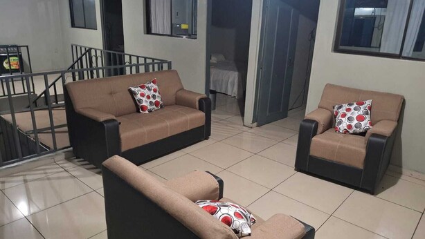 A living room with two sofas, a coffee table, and a staircase. - Spacious apartment (ss)